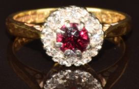An 18ct gold ring set with a round cut garnet surrounded by diamonds, 3.3g, size J