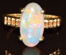 An 18k gold ring set with a Lightning Ridge black opal cabochon of approximately 2.5ct, with