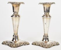 Pair of Edward VII hallmarked silver candlesticks with embossed decoration and tapering stems,