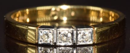 An 18ct gold ring set with three diamonds in square setting, 3g, size N