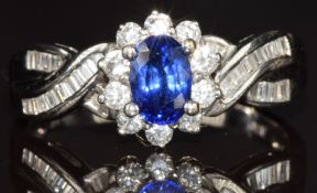 An 18k white gold ring set with an oval cut sapphire of approximately 0.5ct surrounded by round