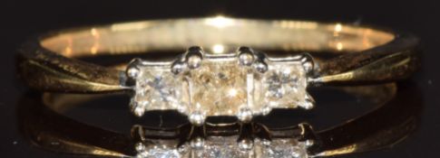 A 9k gold ring set with three princess cut diamonds, 1.6g, size N