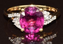 An 18k gold ring set with an oval cut Comeria garnet of approximately 3ct and diamonds, 3.5g, size