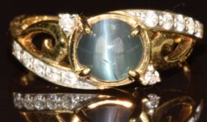An 18k gold ring set with an oval cut cats eye Brazilian Alexandrite cabochon and diamonds, with