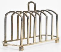 George V hallmarked silver seven bar toast rack made of square section bars and raised on four