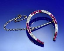 Art Deco brooch in the form of a horseshoe set with graduating calibre cut rubies and graduating