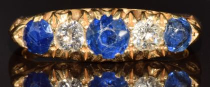 An 18ct gold ring set with three round cut sapphires, the centre sapphire approximately 0.4ct, and