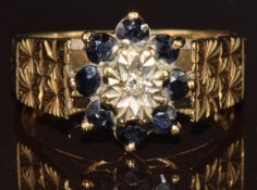 A 9ct gold ring set with a diamond surrounded by sapphires, 3.6g, size N