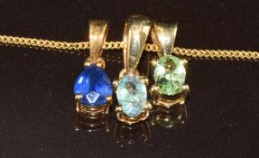 Three 9k gold pendants, one set with an oval cut tsavorite, one oval cut Alexandrite and the other a