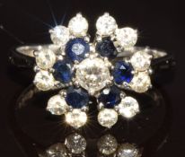An 18ct white gold ring set with round cut sapphires and diamonds in a cluster, the centre diamond
