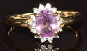 A 9ct gold ring set with an oval cut pink sapphire surrounded by diamonds, 1.7g, size N