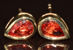 A pair of 9k gold earrings set with pear cut sunset rubies, total carat weight 1.1ct, with
