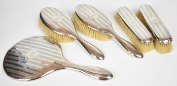 George V hallmarked silver dressing table set comprising hand mirror and two pairs of brushes,