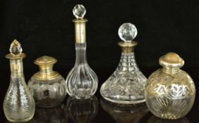 Five hallmarked silver mounted cut glass scent / perfume bottles, tallest 20cm