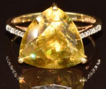 An 18k gold ring set with a trilliant cut sphene of approximately 8.8ct and diamonds to the
