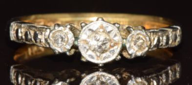 An 18ct gold ring set with three diamonds in a platinum setting, 2.5g, size M