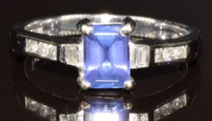 An 18k white gold ring set with an emerald cut tanzanite of approximately 0.7ct, two baguette cut