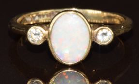 A 9ct gold ring set with an oval opal cabochon and two round brilliant cut diamonds, 2.3g, size K/L