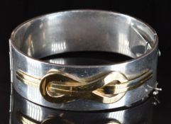 A silver bangle with gold decoration, 99.4g