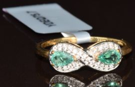A 9k gold ring set with two pear cut Zambian emeralds and white zircons, with Gemporia