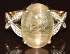 A 9k gold ring set with an oval cats eye zultanite cabochon of approximately 7.6ct and diamonds, 3.