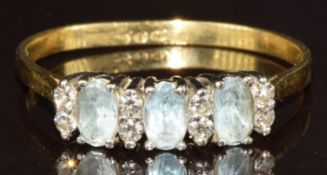 An 18k gold ring set with three oval cut aquamarines and diamonds, 2.7g, size T/U