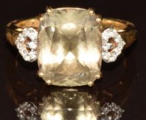 An 18k gold ring set with a cushion cut csarite of approximately 6.4ct and sixteen round cut