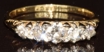 A c1910 18ct gold ring set with five diamonds, the centre diamond approximately 0.2ct, 2.3g, size L