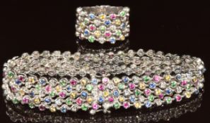 An 18k white gold ring and matching bracelet set with fancy sapphires, rubies, green garnets and