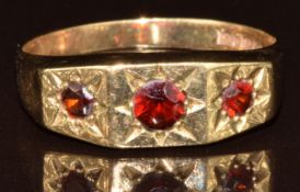 A 9ct gold ring set with three garnets in star settings, 2.5g, size P