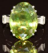 An 18k white gold ring set with an oval cut Ambilobe sphene and baguette cut diamonds, with