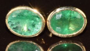 A pair of 9k gold earrings each set with an oval cut Socoto emerald, total carat weight