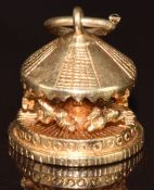 A 9ct gold charm in the form of a moving carousel, 3.9g