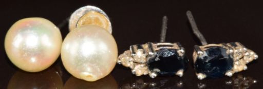 A pair of 14k white gold earrings set with a pearl and a pair of silver earrings set with