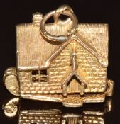 A 9ct gold charm in the form of a house, opening to reveal people, 5g