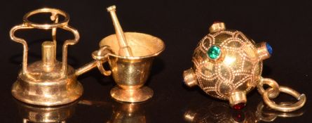 Three yellow metal charms in the form of a sphere, pestle and mortar and burner, tests as 18k