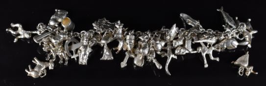 A silver charm bracelet with over forty two silver charms including horse, pheasant, dog, horseshoe,