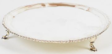 Georgian hallmarked silver card tray or small salver with shaped gadrooned edge, raised on three pad