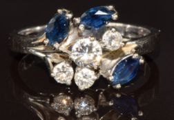 An 18k white gold ring set with three marquise cut sapphires and four round brilliant cut