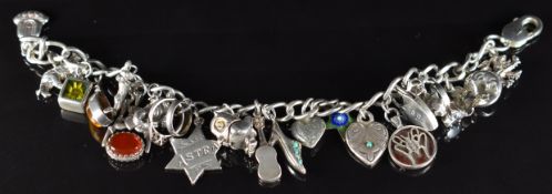 A silver charm bracelet with fourteen silver charms including tiger's eye, owl, shoe set with