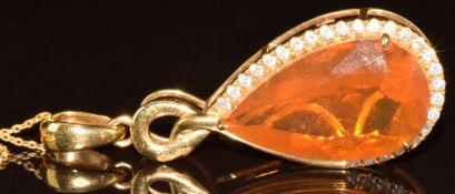 An 18k gold pendant set with a pear cut fire opal of approximately 7.1ct surrounded by diamonds, 7.