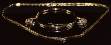 A suite of 14k gold bi-coloured jewellery comprising necklace, bangle and earrings set with