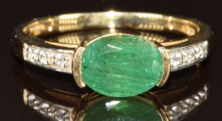 A 9ct gold ring set with an oval cut emerald of approximately 1ct and with diamonds to the