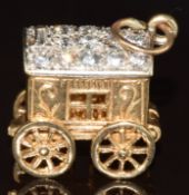 A 9ct gold charm / pendant in the form of a caravan, opening to reveal a fortune teller set with