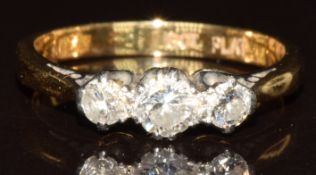 An 18ct gold ring set with three round cut diamonds, the centre diamond approximately 0.23ct, 2.