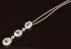 An 18k white gold pedant set with three oval cut aquamarines, two round cut pink sapphires and