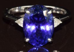 A platinum ring set with an oval cut AAA tanzanite of approximately 5.1ct and two trillion cut