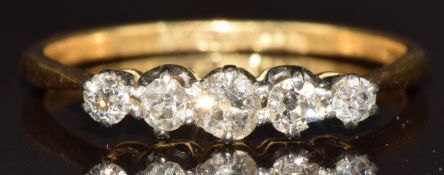 An 18ct gold ring set with five diamonds in platinum setting, the centre diamond 0.12ct, 2.4g,
