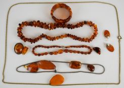 A collection of amber jewellery including a pair of earrings, three brooches, three pendants, two