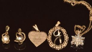 A collection of 9ct gold jewellery comprising two pendants set with pearls, heart pendant, initial